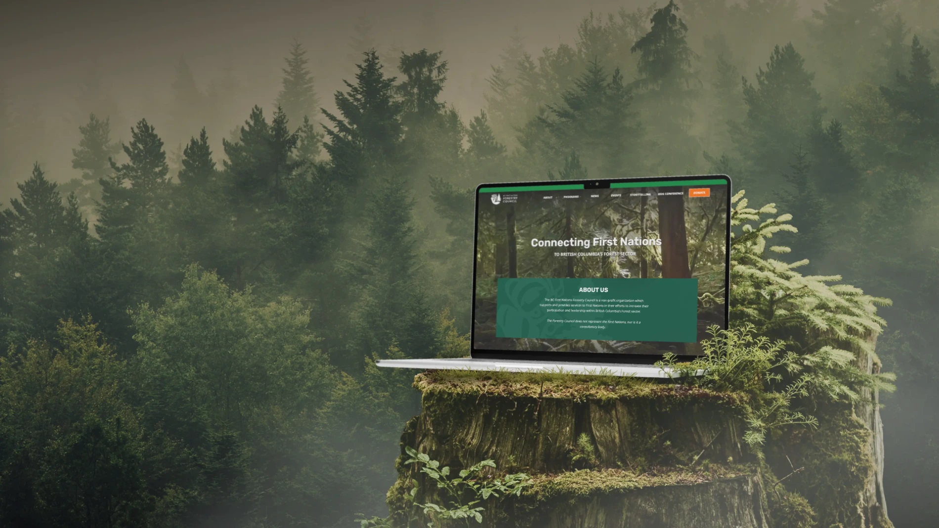 Laptop displaying "Connecting First Nations TO BRITISH COLUMBIA'S FOREST SECTOR" on a mossy tree stump in a misty forest.